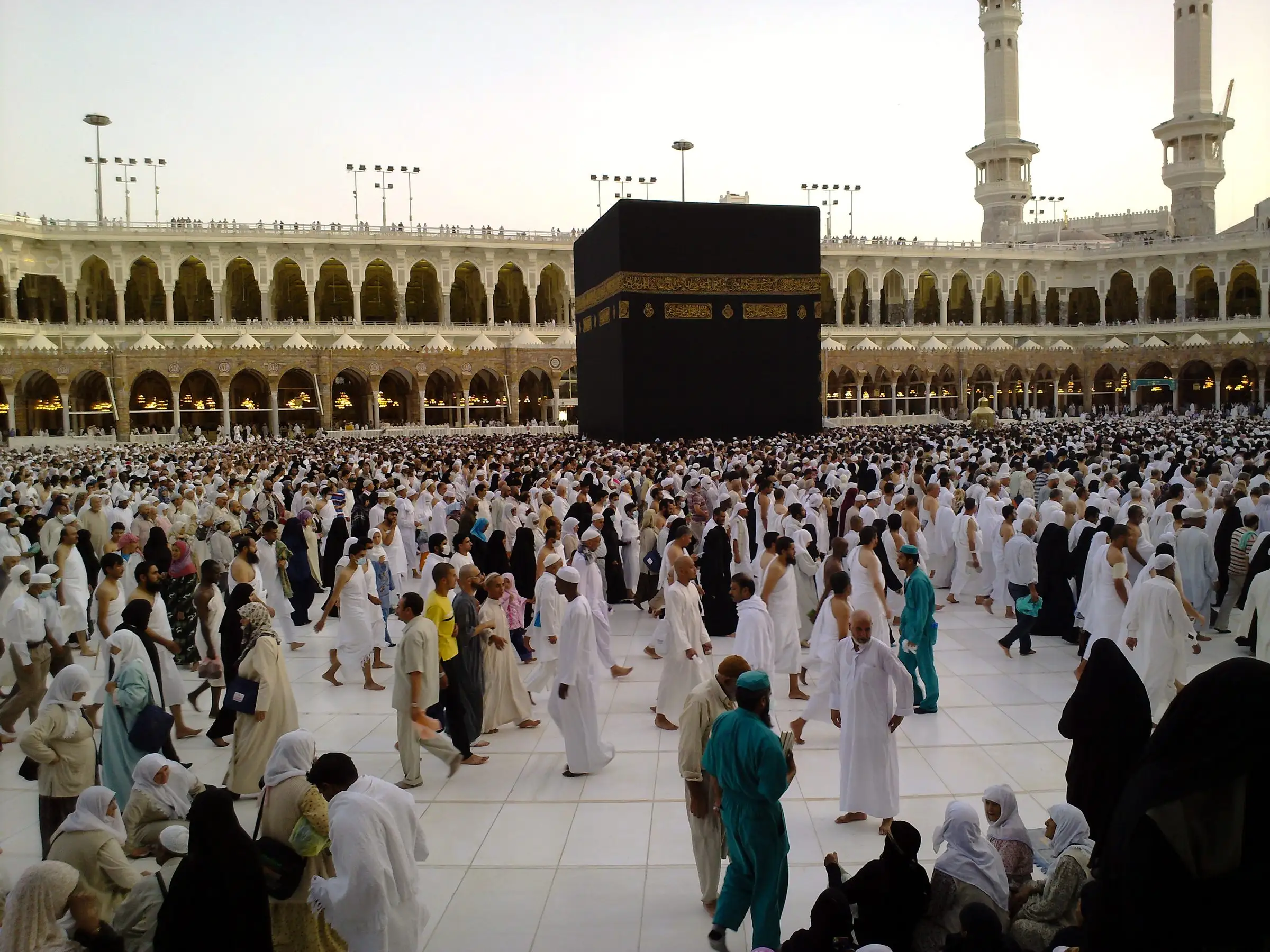 The Kaaba in Masjid al-Haram, Makkah, surrounded by pilgrims in the evening