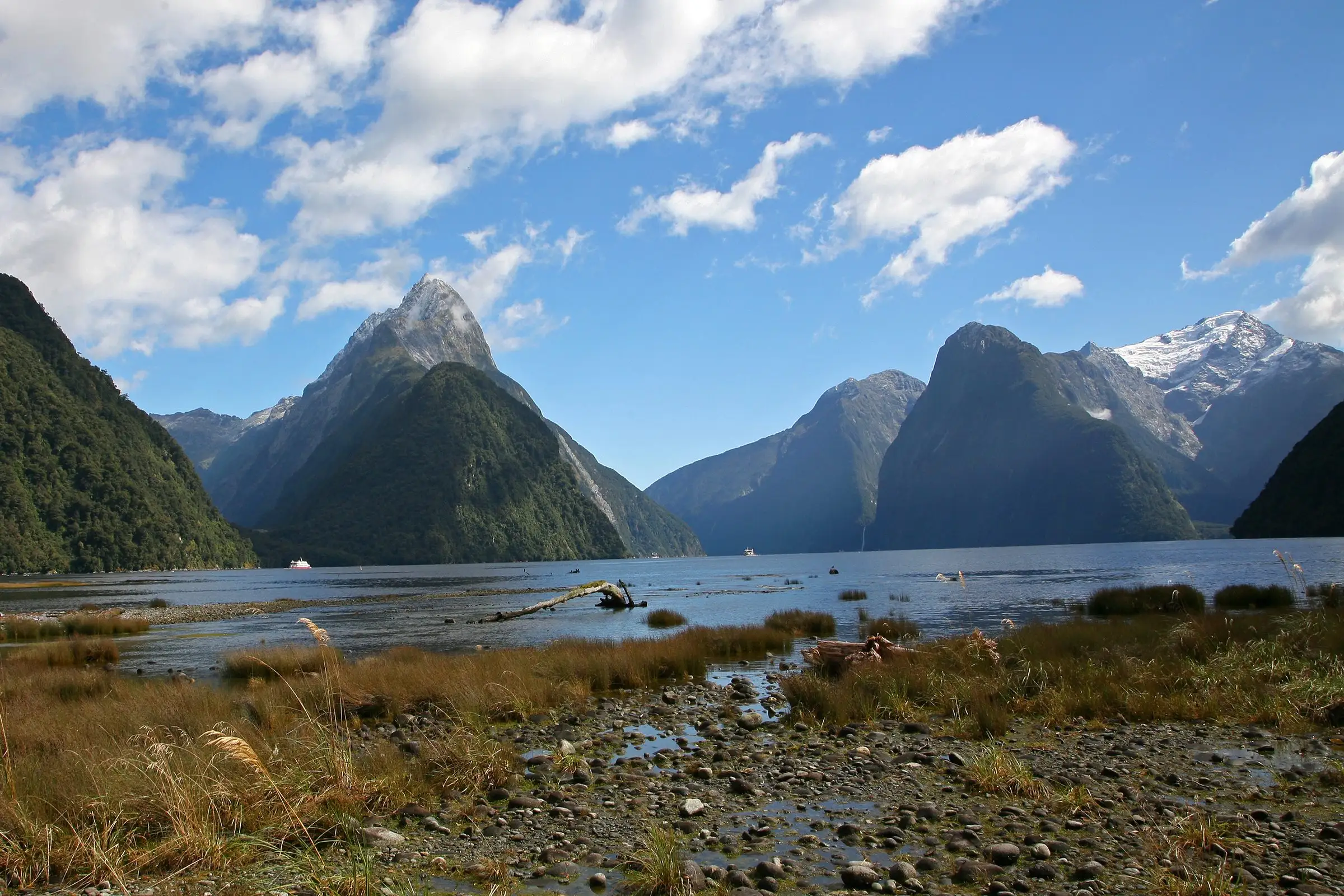 Mitre Peak rising above the water of Milford Sound under a blue sky