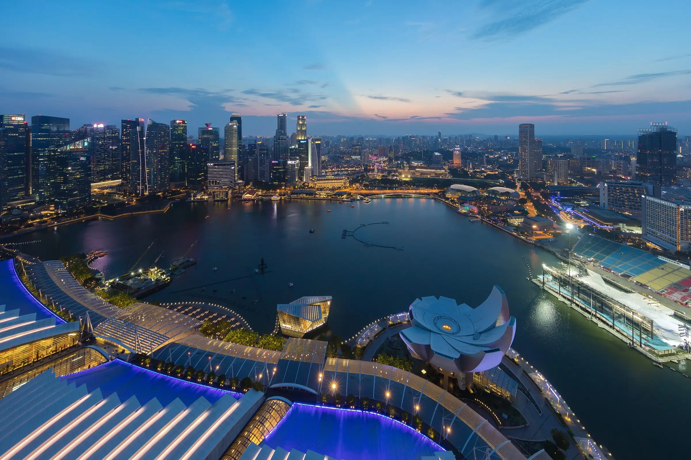 Marina Bay in Singapore at blue hour with the city lights coming on