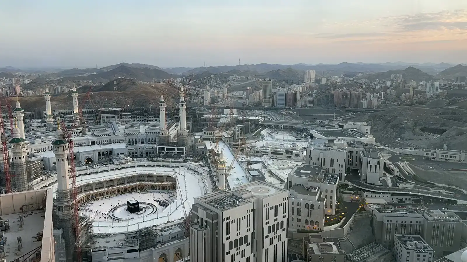 Pilgrims walking across the courtyard of Masjid an-Nabawi in Madinah in warm morning light