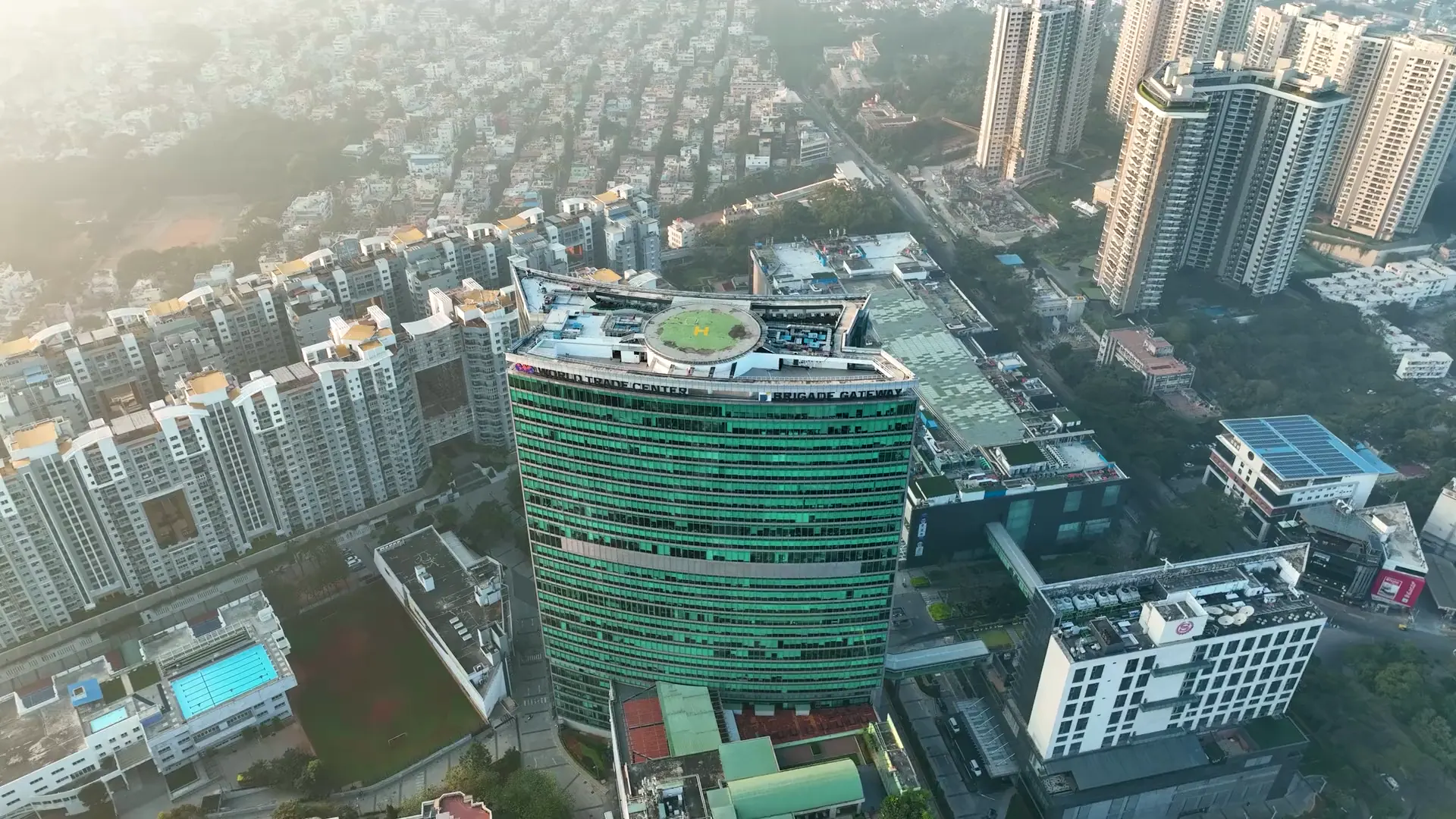 A glass office tower in a Bengaluru tech park at sunrise